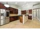 Gourmet kitchen with stainless steel appliances, custom backsplash, stone accents, and large center island at 6967 W Irma Ln, Glendale, AZ 85308