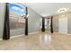 Bright living room with large windows, vaulted ceilings, and tile flooring at 6967 W Irma Ln, Glendale, AZ 85308