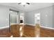 Large main bedroom with hardwood floors, neutral paint, and ensuite bathroom and walk-in closet at 6967 W Irma Ln, Glendale, AZ 85308