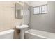 A full bathroom with a combined shower and tub, pedestal sink, and tiled walls is shown at 716 S Lewis --, Mesa, AZ 85210