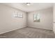 A sunlit bedroom with two windows, neutral colored walls and gray carpet, creating a calm atmosphere at 716 S Lewis --, Mesa, AZ 85210