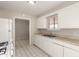 A view of kitchen with the sink, white cabinetry and appliance, connecting to another room through a doorway at 716 S Lewis --, Mesa, AZ 85210