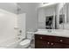 Well-lit bathroom with a shower-tub combo and dark wood vanity at 7423 S 28Th Pl, Phoenix, AZ 85042