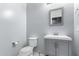 Powder room features gray vanity with modern fixtures and a framed mirror at 7423 S 28Th Pl, Phoenix, AZ 85042