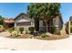 Inviting home exterior with desert landscaping, mature tree, and a stone-accented facade at 7423 S 28Th Pl, Phoenix, AZ 85042
