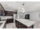 Open kitchen with large island, dark wood cabinets, stainless steel appliances, and view into living area at 7423 S 28Th Pl, Phoenix, AZ 85042