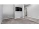 Neutral living room featuring plush gray carpeting and a modern wall-mounted television at 7423 S 28Th Pl, Phoenix, AZ 85042