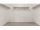 Walk-in closet featuring neutral carpet and wooden rods for ample storage at 7423 S 28Th Pl, Phoenix, AZ 85042