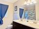 Bright bathroom features a double vanity, large mirror, and bathtub with decorative shower curtain at 8343 E Edward Ave, Scottsdale, AZ 85250