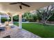 Covered outdoor patio with fan, seating, and backyard view of landscaping and hot tub at 8618 E Via De Encanto --, Scottsdale, AZ 85258