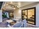 Covered outdoor patio with fan, seating, and view into the home through sliding glass doors at 8618 E Via De Encanto --, Scottsdale, AZ 85258
