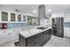 Modern kitchen with white cabinets, marble countertops, and stainless steel appliances, including an island range at 8618 E Via De Encanto --, Scottsdale, AZ 85258