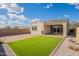 Exterior view of home's backyard featuring new turf, brick pavers and desert landscaping at 9155 W Minnezona Ave, Phoenix, AZ 85037