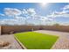 Backyard featuring a rectangular patch of green grass surrounded by decorative rock and brick pavers at 9155 W Minnezona Ave, Phoenix, AZ 85037