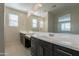 Bathroom featuring double sink vanity with quartz countertops and large mirror reflecting a glass enclosed shower at 9155 W Minnezona Ave, Phoenix, AZ 85037