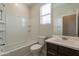 Bathroom featuring a tub, toilet, vanity with sink, and large mirror at 9155 W Minnezona Ave, Phoenix, AZ 85037