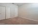 Bedroom showcasing neutral walls, plush carpeting, and a closet with sliding doors for ample storage at 9155 W Minnezona Ave, Phoenix, AZ 85037