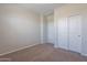 Neutral bedroom featuring closet with sliding doors, carpeted flooring, and neutral walls at 9155 W Minnezona Ave, Phoenix, AZ 85037