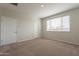 Bright bedroom featuring neutral walls, plush carpeting, and a window with blinds allowing natural light at 9155 W Minnezona Ave, Phoenix, AZ 85037