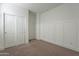 Bedroom featuring neutral walls, plush carpeting, wainscotting, and a closet with sliding doors at 9155 W Minnezona Ave, Phoenix, AZ 85037