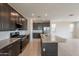Stylish kitchen featuring stainless appliances, granite counters, dark cabinetry and a large island at 9155 W Minnezona Ave, Phoenix, AZ 85037