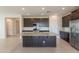 Modern kitchen with stainless steel appliances and a central island with breakfast bar seating at 9155 W Minnezona Ave, Phoenix, AZ 85037