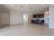 Open-concept space with tile floors adjoining the kitchen with dark cabinets and stainless appliances at 9155 W Minnezona Ave, Phoenix, AZ 85037