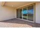 Covered patio with brick flooring and sliding glass doors leading to backyard at 9155 W Minnezona Ave, Phoenix, AZ 85037