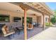 Covered back patio featuring stone pillars, ceiling fan, outdoor furniture, and a mounted television for outdoor enjoyment at 9421 E Calle De Valle Dr, Scottsdale, AZ 85255