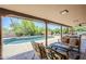 Covered back patio with stylish outdoor furniture and a view of a sparkling pool surrounded by lush landscaping at 9421 E Calle De Valle Dr, Scottsdale, AZ 85255