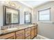 Bathroom with double sinks, granite countertops, and framed mirrors at 9421 E Calle De Valle Dr, Scottsdale, AZ 85255