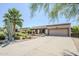 Home exterior with desert landscaping, mature palm trees, stucco facade and three car garage at 9421 E Calle De Valle Dr, Scottsdale, AZ 85255