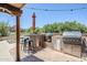 Outdoor kitchen features stainless steel grill, ceramic cooker, tile flooring and bar seating at 9421 E Calle De Valle Dr, Scottsdale, AZ 85255