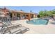 Beautiful pool area with lounge chairs, patio cover, dining area, bar and outdoor fireplace at 9421 E Calle De Valle Dr, Scottsdale, AZ 85255