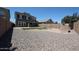 Well-maintained backyard featuring gravel, a stone fireplace, a small patch of grass, and a playset at 10036 E Naranja Ave, Mesa, AZ 85209