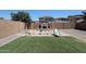 Backyard with artificial grass, a playground, and stone accents at 10036 E Naranja Ave, Mesa, AZ 85209