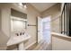 Well-lit bathroom with a pedestal sink, modern mirror, and a view into the adjacent living area at 10036 E Naranja Ave, Mesa, AZ 85209