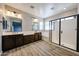A modern bathroom with wood-look floors, double sinks, a tub, and a glass-enclosed shower at 10036 E Naranja Ave, Mesa, AZ 85209