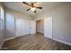 Bedroom with a ceiling fan, wood-look tile flooring, and a closet and doorway for easy access at 10036 E Naranja Ave, Mesa, AZ 85209