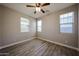 Bright bedroom featuring wood-look tile flooring, a ceiling fan, and natural light from three windows at 10036 E Naranja Ave, Mesa, AZ 85209