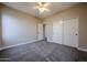 Carpeted bedroom with ceiling fan, closet, baseboards, neutral paint, and white trim at 10036 E Naranja Ave, Mesa, AZ 85209