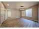 Bright dining area with wood-look tile flooring, modern light fixture, and a large window at 10036 E Naranja Ave, Mesa, AZ 85209
