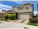 Charming two-story home with a two-car garage, well-maintained lawn, and mature landscaping under a bright sky at 10036 E Naranja Ave, Mesa, AZ 85209