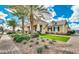 Inviting home exterior featuring lush landscaping, desert plants, and a paver walkway to the front door at 10036 E Naranja Ave, Mesa, AZ 85209