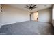 A large carpeted main bedroom with a ceiling fan, neutral paint, and access to the bathroom at 10036 E Naranja Ave, Mesa, AZ 85209