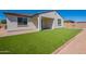 This backyard boasts a green lawn, a covered patio, and a stucco exterior with decorative roof tiles at 10348 E Tupelo Ave, Mesa, AZ 85212