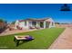 Outdoor backyard area with a fire pit, covered patio, and manicured lawn for entertaining at 10348 E Tupelo Ave, Mesa, AZ 85212