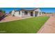 This home's exterior features a green lawn, a covered patio, and a backyard ready for new landscaping at 10348 E Tupelo Ave, Mesa, AZ 85212