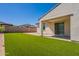 An outdoor covered patio and artificial turf in the backyard of this desert home at 10348 E Tupelo Ave, Mesa, AZ 85212