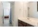 This bathroom boasts a white vanity, spacious sink and a shower-tub combo with a blue-patterned curtain at 10348 E Tupelo Ave, Mesa, AZ 85212